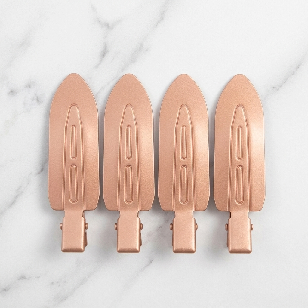 Four Olla Bella No-Crease Cuties - Creaseless Hair Clips arranged in a row on a white marble background.