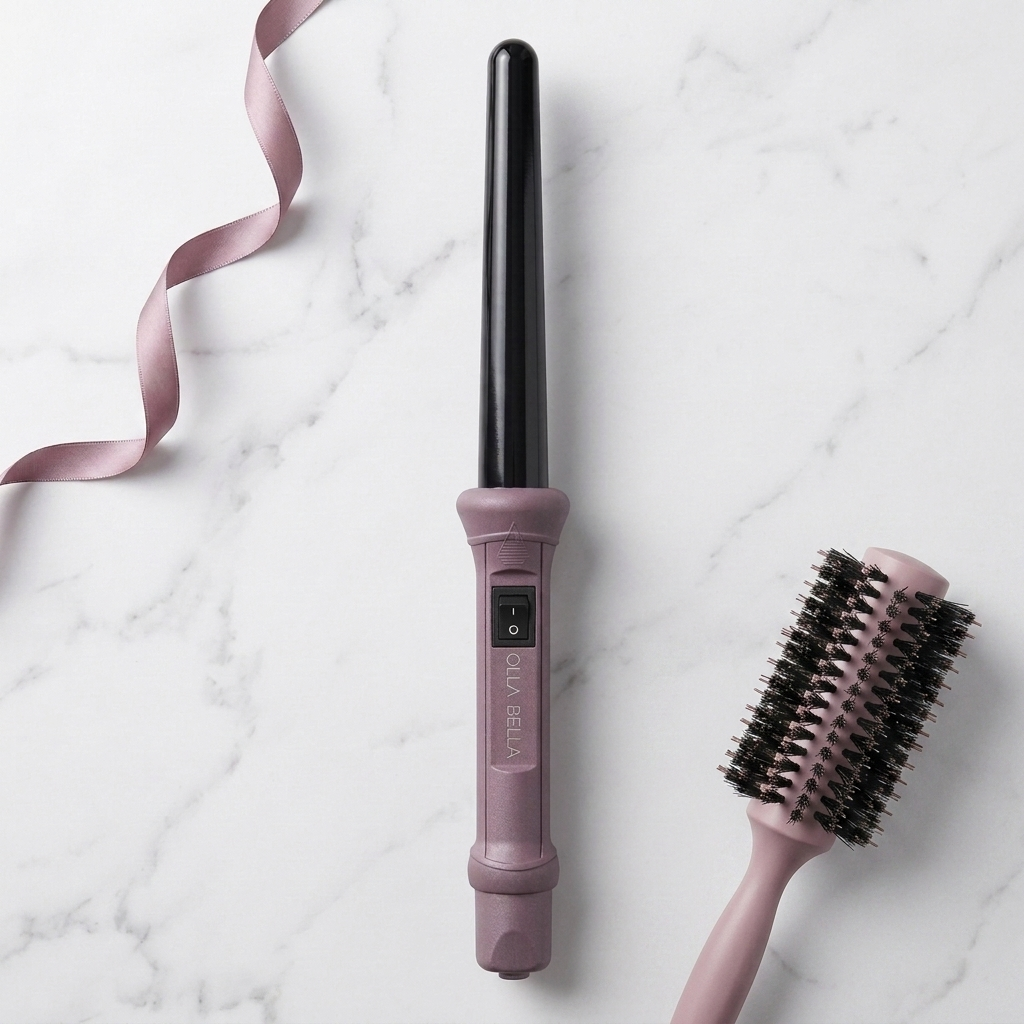 The Olla Bella 1" Ceramic Curling Iron in Plum Metallic shown alongside a matching pink hairbrush on a white marble background with a pink ribbon.
